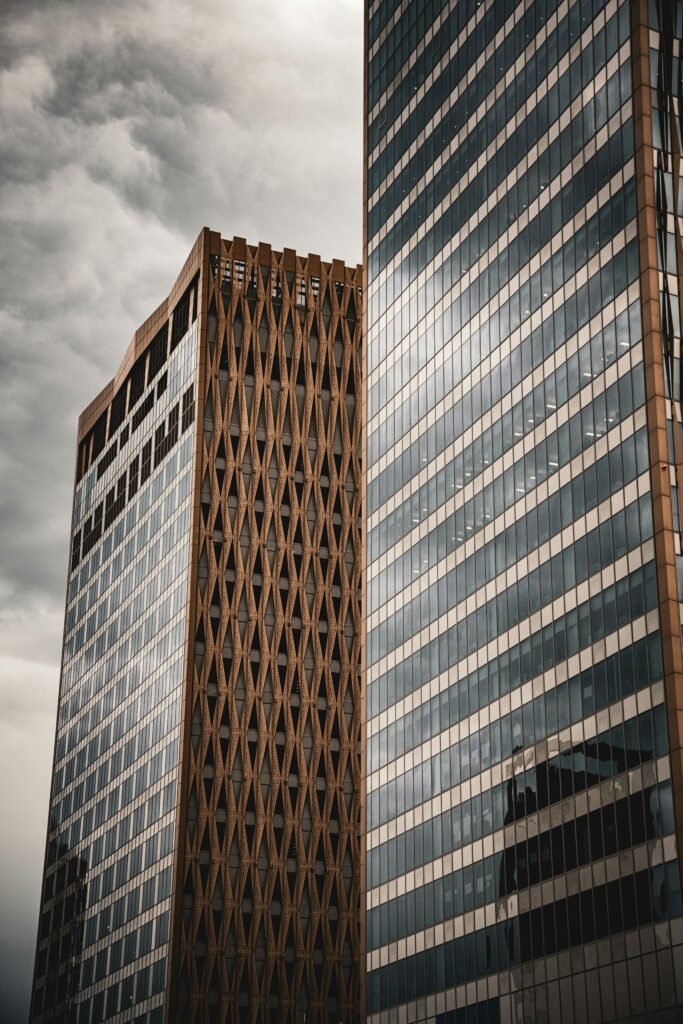 Modern skyscrapers in Kuwait City against a dramatic cloudy sky, showcasing urban architecture.