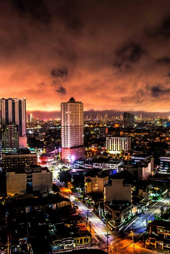 Stunning illuminated skyline view of Manila, Philippines at night with a dramatic sky.