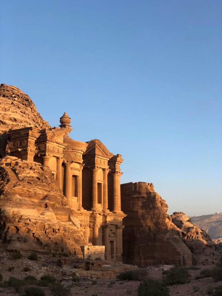 Capture of the ancient Petra Monastery in Jordan illuminated by sunset, showcasing stunning sandstone architecture.