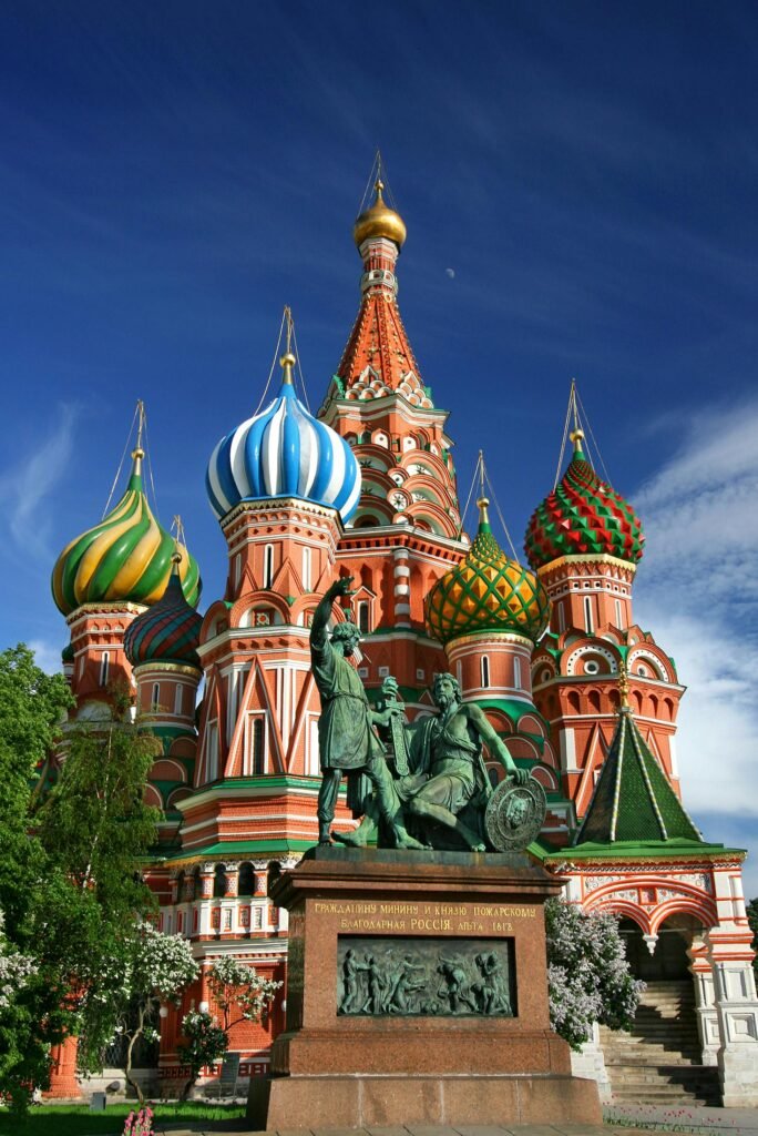 Vibrant view of St. Basil's Cathedral's colorful domes and statues on a sunny day in Moscow.